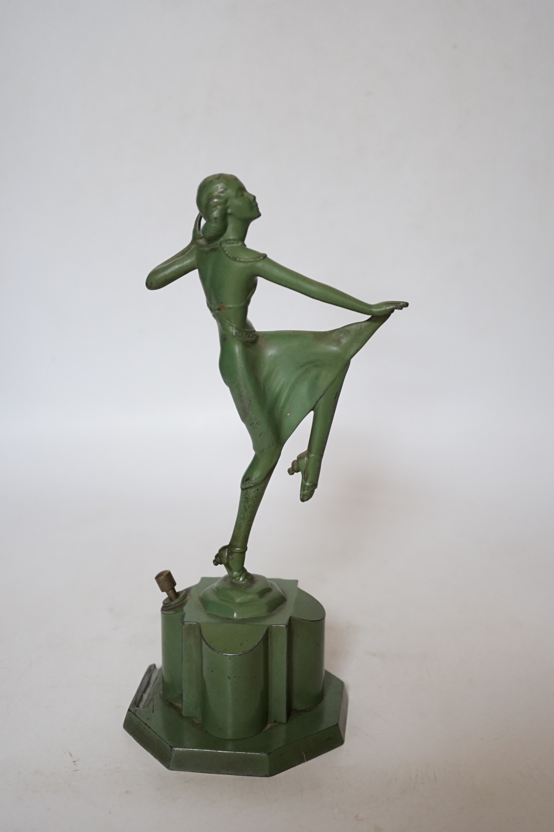 An Art Deco match striker in the form of a dancing woman, with patinated green finish, 25cm